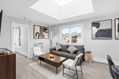 a living room with a couch and a table at Spacious 2BR Apt with Balcony only 15 Min Bus to Manhattan in Jersey City
