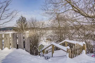 a fence covered in snow next to a field at Lakefront Escape with Dock! Hudson Valley Home in Hillsdale