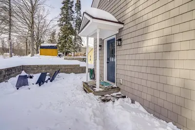 a house with a blue door in the snow at Lakefront Escape with Dock! Hudson Valley Home in Hillsdale