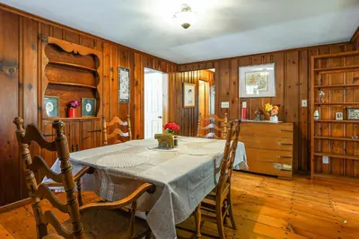a dining room with a table and wooden walls at Stratford Family Home Near Forest and Historic Sites in Stratford