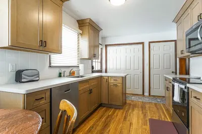 a kitchen with wooden cabinets and a wooden table at Stratford Family Home Near Forest and Historic Sites in Stratford