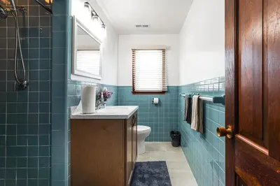 a bathroom with blue tiled walls and a toilet at Stratford Family Home Near Forest and Historic Sites in Stratford