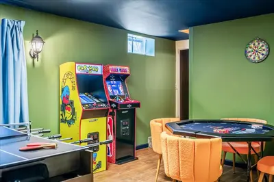 a room with a pinball machine and a table at Movie Theater Game Room Resort Amenity Access in Tobyhanna