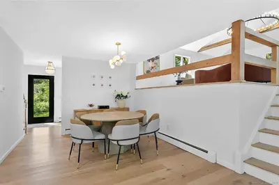 a dining room with a table and chairs and a staircase at Renovated Retreat with Heated Pool in Redding