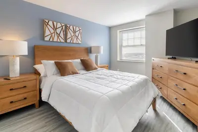 a bedroom with a white bed and a flat screen tv at Landing Stylish 1BD Gym in New Haven