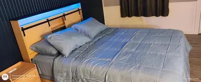 a bedroom with a bed with blue sheets and pillows at Windmill Motel Restaurant in Bernardston