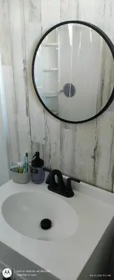 a mirror sitting on top of a white sink at Windmill Motel Restaurant in Bernardston