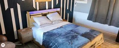 a bedroom with a bed with a black and white headboard at Windmill Motel Restaurant in Bernardston