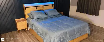 a bedroom with a bed with a blue comforter at Windmill Motel Restaurant in Bernardston