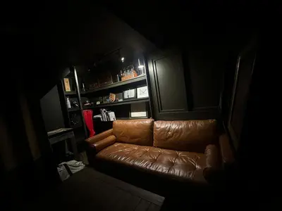 a brown leather couch in a dark room at The Vault - Hidden Playroom For Couples - Private Hot Tub - Mountain Views - Riverfront in Barryville