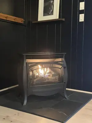 a fireplace with a fire in it in a room at Gilded Cage Escapes - Hidden Playroom For Couples - Private Hot Tub - Mountain Views - Riverfront in Lackawaxen