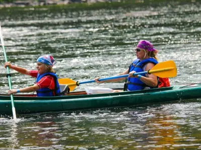 two women are in a kayak on the water at Gilded Cage Escapes - Hidden Playroom For Couples - Private Hot Tub - Mountain Views - Riverfront in Lackawaxen