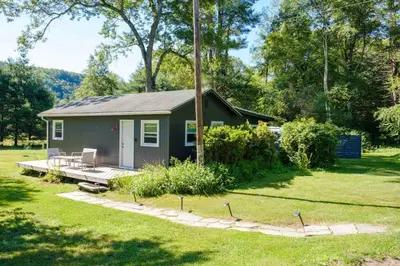 a tiny house in the middle of a yard at Gilded Cage Escapes - Hidden Playroom For Couples - Private Hot Tub - Mountain Views - Riverfront in Lackawaxen