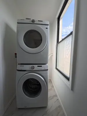a washing machine in a room with a window at Duplex 15 mins from Time Square! in West New York