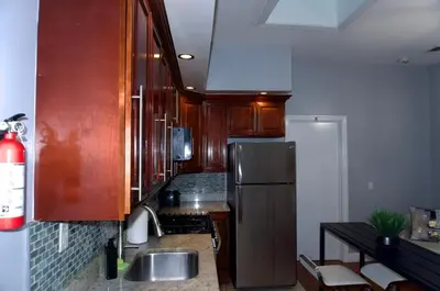 a kitchen with wooden cabinets and a stainless steel refrigerator at New York private room 31 in West New York