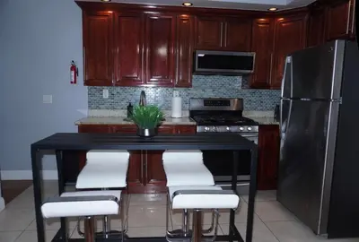 a kitchen with a black table with chairs and a refrigerator at New York private room 31 in West New York