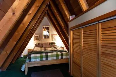 a bedroom with a bed in a attic at Catskills Aframe, Water View, Goat Sanctuary in Napanoch