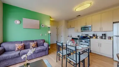 a living room with a couch and a table and a kitchen at Stylish Home With Free ParkingFA in Stamford
