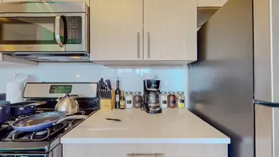 a kitchen with a counter with a stove and a microwave at Stylish Home With Free ParkingFA in Stamford