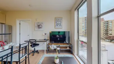 a living room with a large window and a table and a television at Stylish Home With Free ParkingFA in Stamford