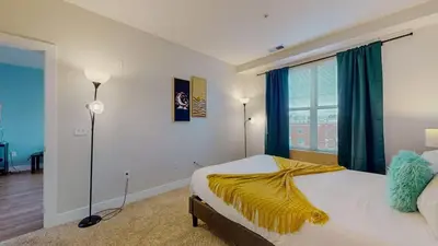 a bedroom with a bed with a yellow blanket on it at Stylish Home With Free ParkingZA in Stamford