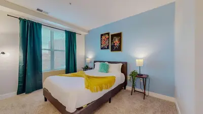 a bedroom with a bed with blue walls and a window at Stylish Home With Free ParkingZA in Stamford
