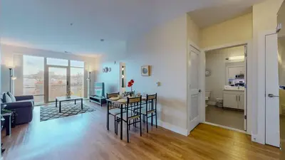 a living room with a table and chairs and a kitchen at Stylish Home With Free ParkingZA in Stamford