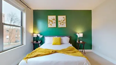 a bedroom with a bed with a green wall at Stylish Home with Free Parking in Stamford