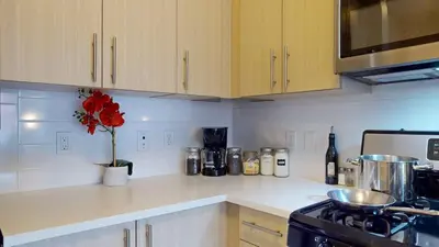 a kitchen with a stove and a vase with red flowers at Stylish Home with Free Parking in Stamford