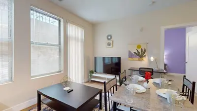 a dining room with tables and chairs and a tv at Stylish Home and Cozy in Stamford