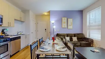 a kitchen and living room with a table and a couch at Stylish Home and Cozy in Stamford