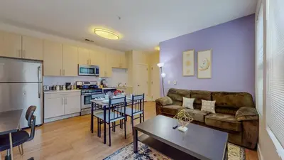 a living room and kitchen with a couch and a table at Stylish Home and Cozy in Stamford