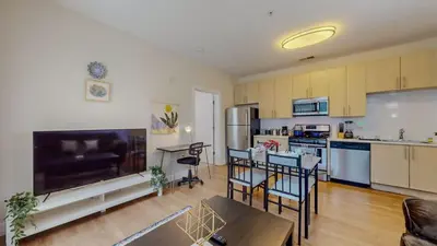 a large living room with a kitchen and a table at Stylish Home and Cozy in Stamford