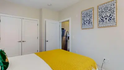 a white bedroom with a bed with a yellow blanket at Stylish Home and Cozy in Stamford