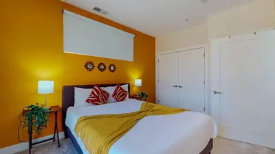a bedroom with a large bed with orange walls at Stylish Home and Cozy200 in Stamford