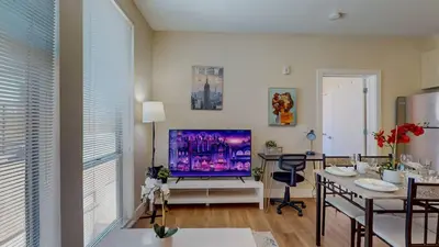 a living room with a television and a dining room at Stylish Home and Cozy200 in Stamford