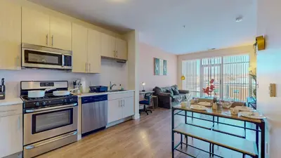 a kitchen with stainless steel appliances and a living room at Comfort Meets Convenience Parking Gym near NYC in Stamford