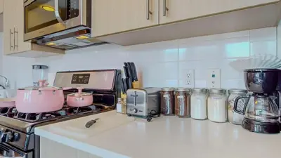 a kitchen counter with a stove with pots and pans at Cozy Modern Home Free Parking in Stamford