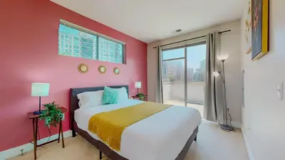 a bedroom with a large bed with a pink wall at Cozy Modern Home Free Parking in Stamford