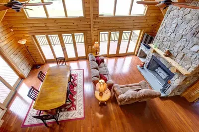 an overhead view of a living room with a stone fireplace at Waterfront Catskills Log Cabin with Hot Tub & Views in Stamford
