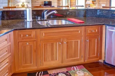 a kitchen with wooden cabinets and a sink at Waterfront Catskills Log Cabin with Hot Tub & Views in Stamford