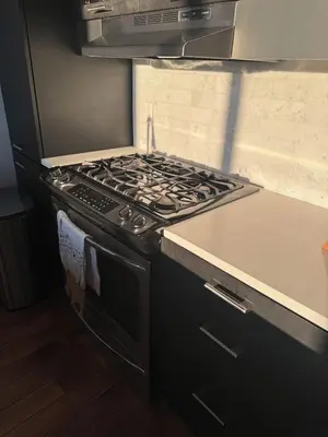 a stove top oven in a kitchen with a counter at Sky-High Sanctuary Penthouse with Panoramic Views in Brooklyn