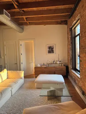 a living room with a couch and a brick wall at Sky-High Sanctuary Penthouse with Panoramic Views in Brooklyn