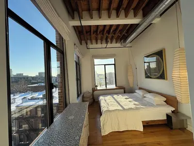 a bedroom with a bed and a large window at Sky-High Sanctuary Penthouse with Panoramic Views in Brooklyn