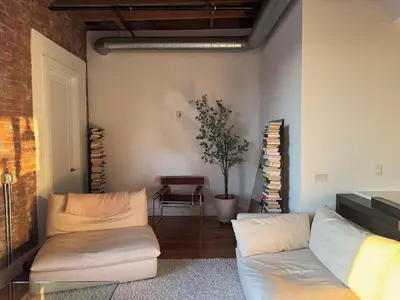 a living room with a couch and a table at Sky-High Sanctuary Penthouse with Panoramic Views in Brooklyn