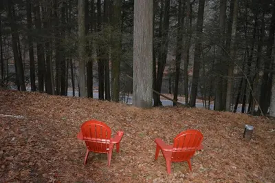 two red chairs sitting in the leaves in the woods at Pocono Pride in East Stroudsburg