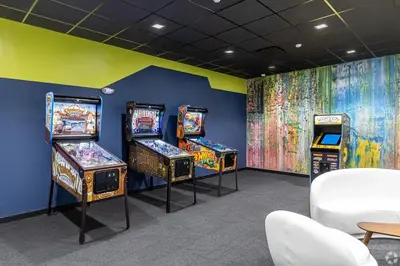 a room with three pinball machines and a mural at Landing Chic 1BD Pool Game Room in Hartford