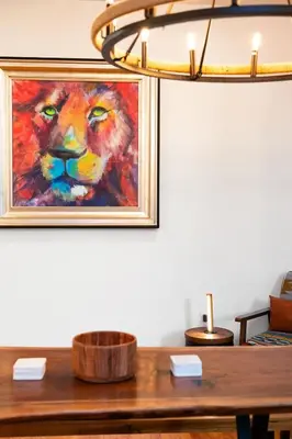 a painting of a lion on a wall next to a table at Summit Haus Cozy Getaway in the Poconos in Pocono Summit