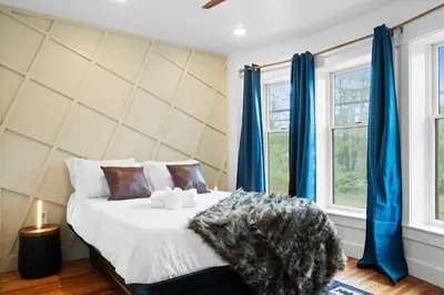 a bedroom with a bed with blue curtains at Summit Woods Hideaway Cozy Pocono Getaway in Pocono Summit