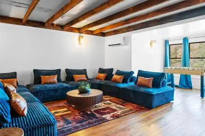 a living room with blue couches and a table at Lakeside Serenity Retreat Near Kalahari Resort in Pocono Summit
